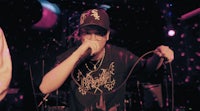 a man in a hat is singing into a microphone